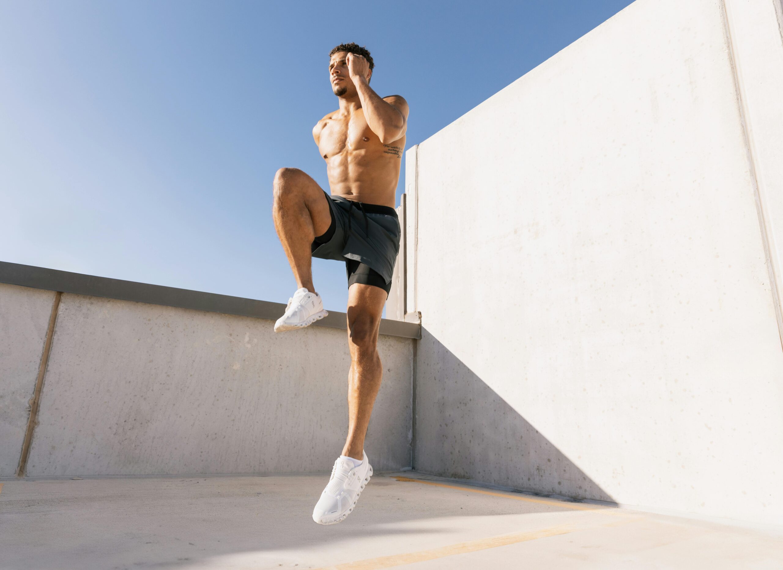 Male athlete jumps into the air during a workout.