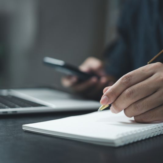Contact Us A person making notes to provide product feedback.