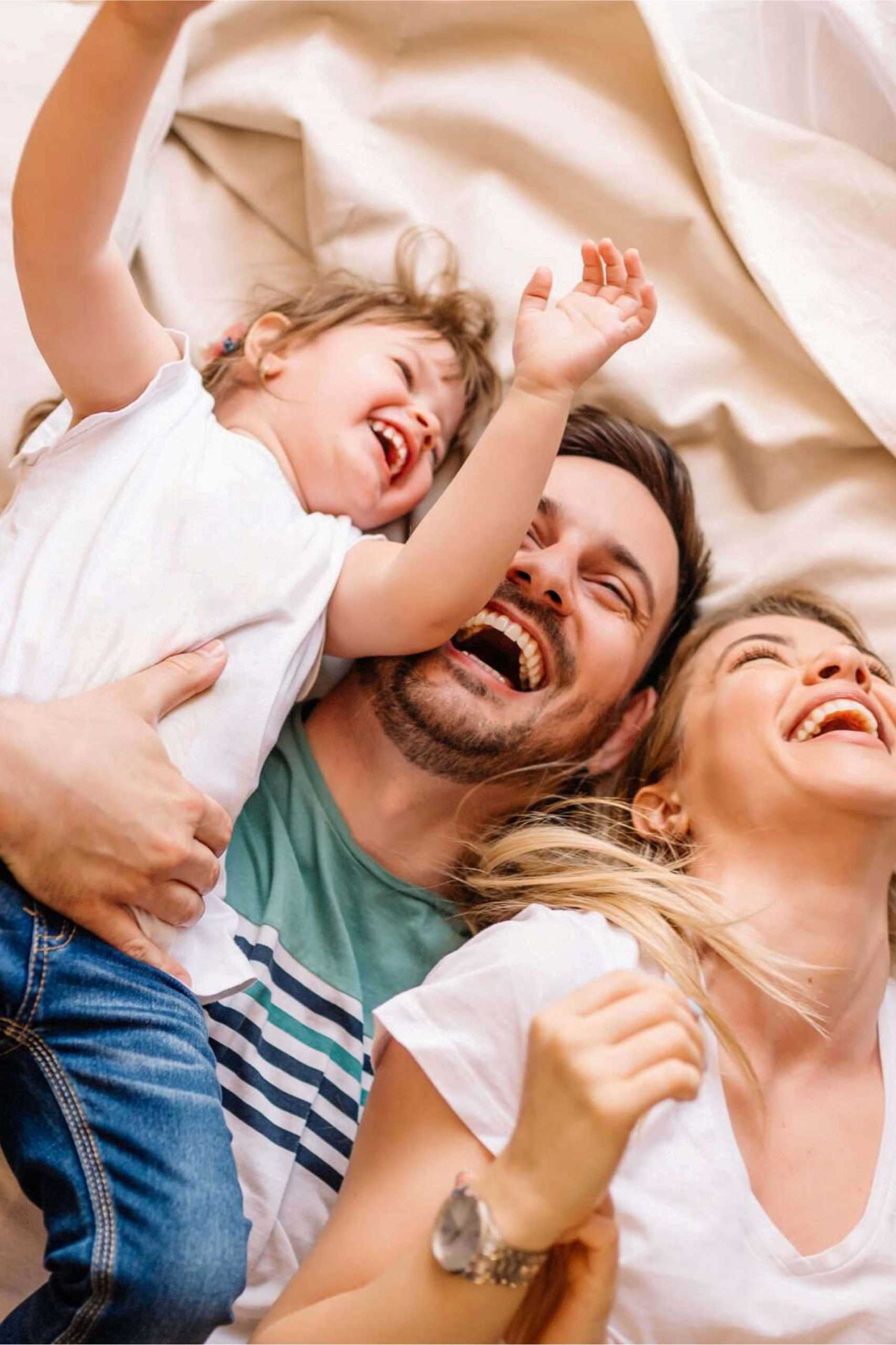Family Laughing A small family laughing together on a bed that contains XO-NANO Smartfoam.