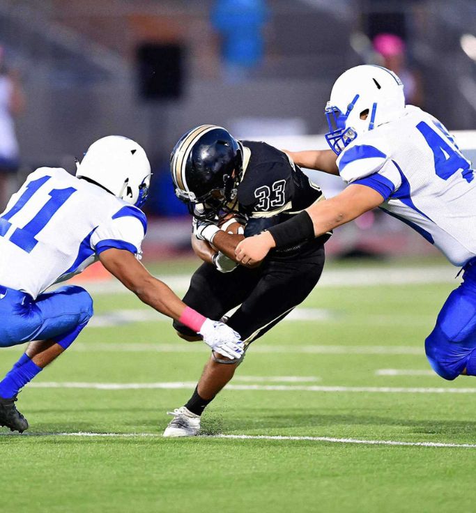 Football Players A group of tackle football players preparing for impact. XO-NANO smart foam in their padding can provide insights potentially reducing the risk of injury.