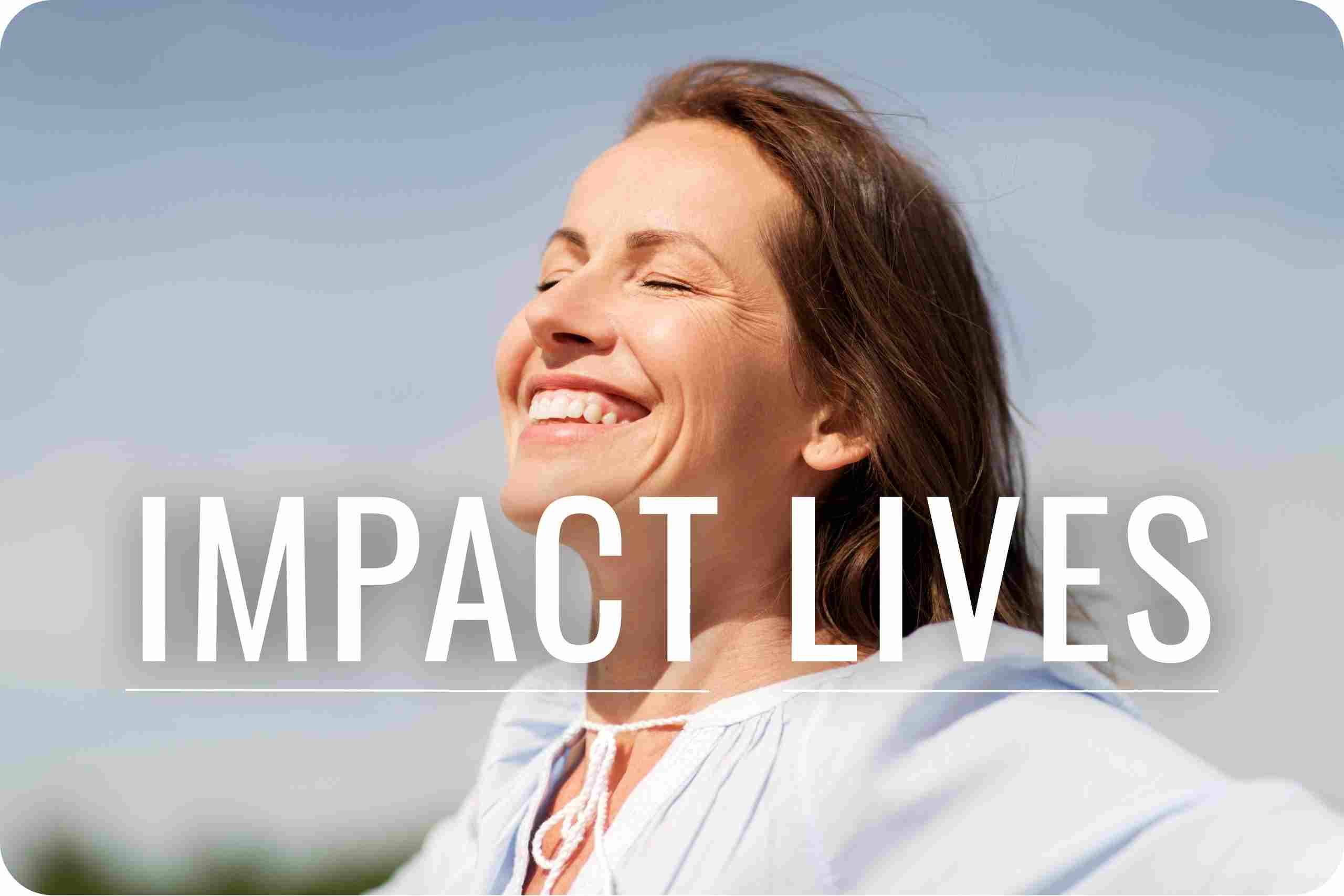 A woman smiling as the sun beams on her face.