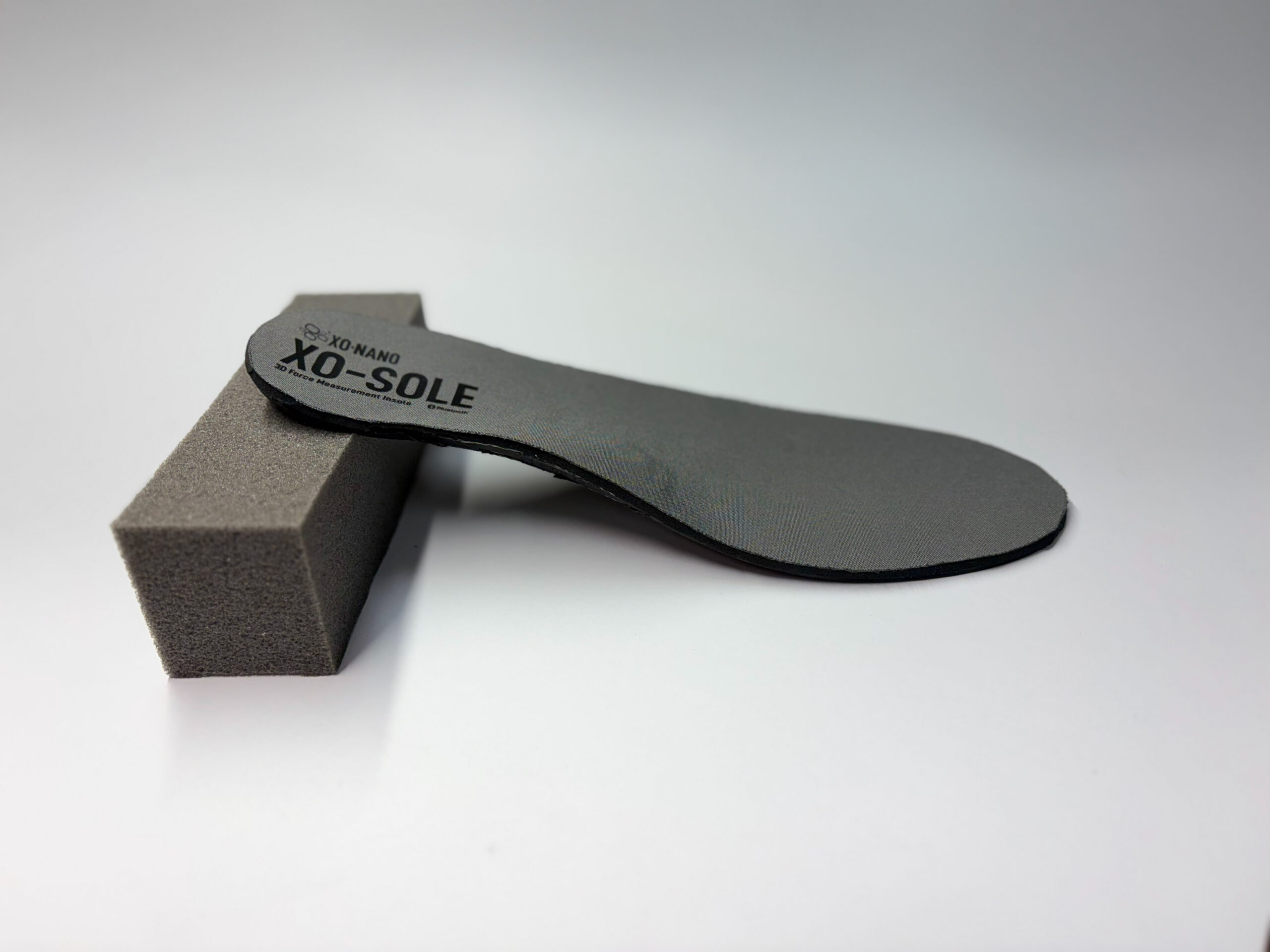 An XO-SOLE balancing on another against a gray background.