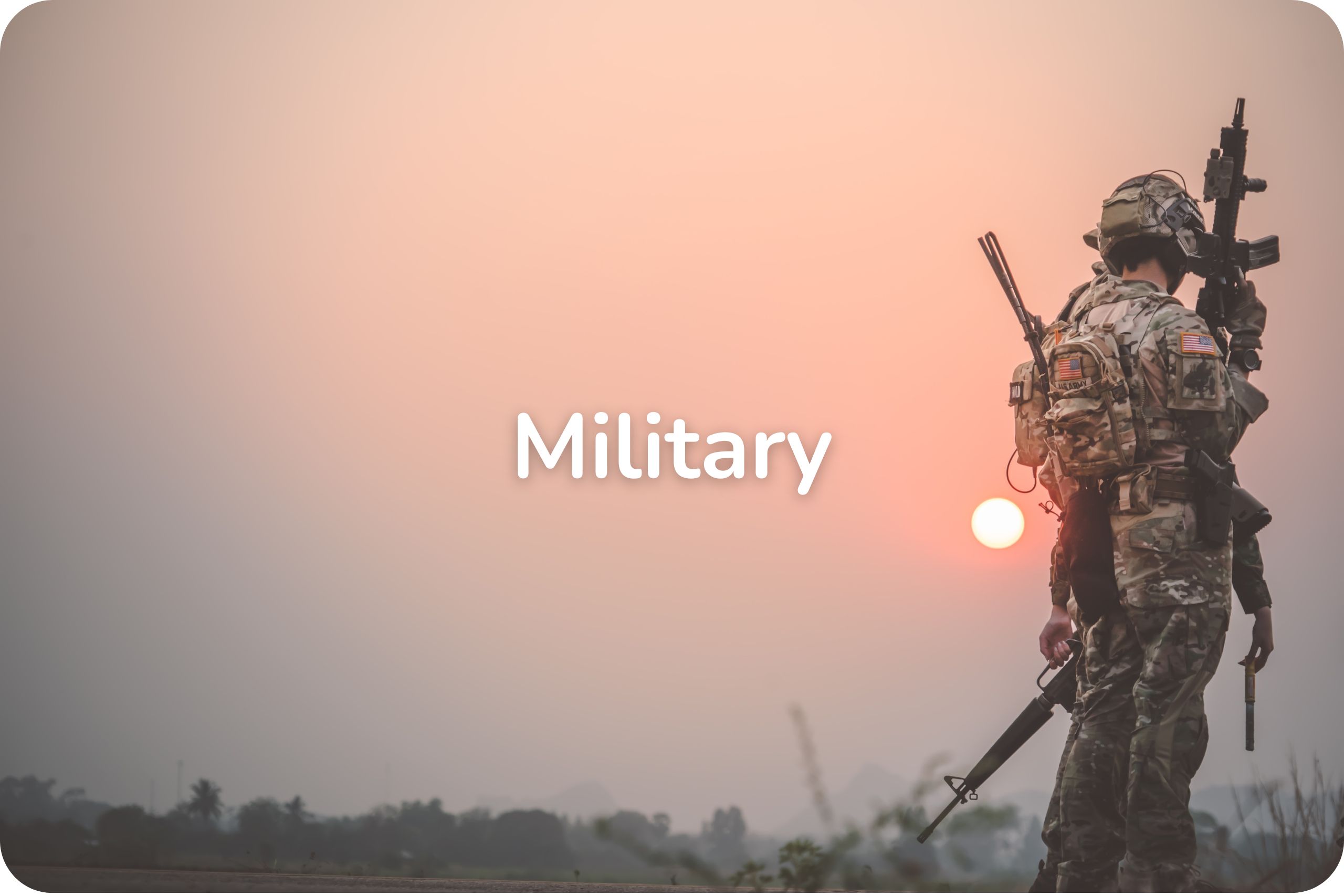 A group of military personnel in a field during sunset.